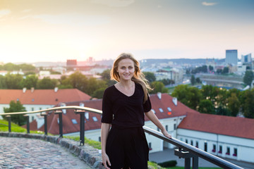 Attractive young blonde woman in the city at sunset