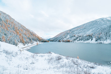 Winter landscape with lake. Beautiful landscape. Mountains covered by snow.