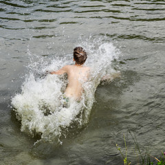 boy jumping into the water .