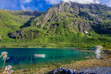White boat in the lake with view to mountains in the Norway at summer