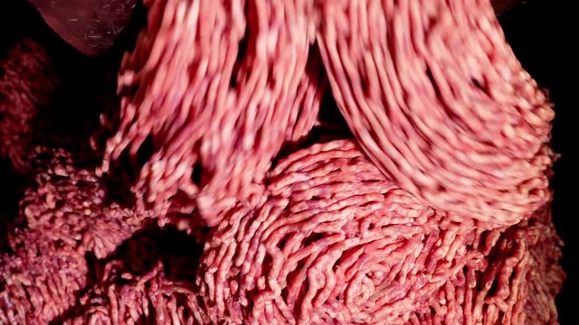 Processing lard or meat in minced meat on a huge meat grinder at a meat factory closeup.