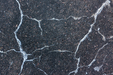 White cracks on an old concrete paving slab