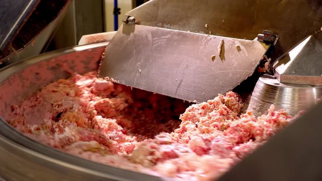 Processing lard or meat in minced meat on a huge meat grinder at a meat factory closeup.
