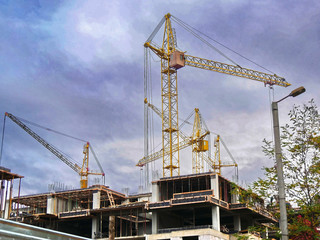 Fototapeta na wymiar Construction cranes near building under construction. Construction site.