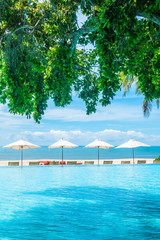 Beautiful luxury umbrella and chair around swimming pool in hotel and resort