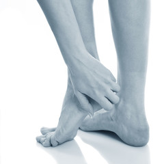 Partial view of woman touching foot feeling pain