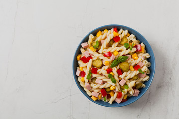 Italian fusilli pasta in a salad with ham and vegetables.