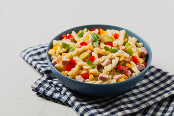 Italian fusilli pasta in a salad with ham and vegetables.