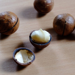 Obraz premium Macadamia nuts in shell on wooden table