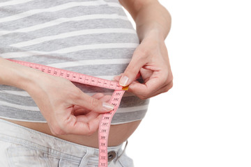 Pregnant woman with a tape measure in the hands