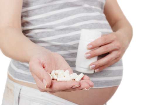 Pregnant woman with different pills in the hand
