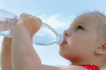 A child drinks water on a hot day quenching thirst