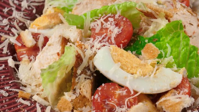 Fresh Caesar salad with parmesan cheese, close-up view, loop
