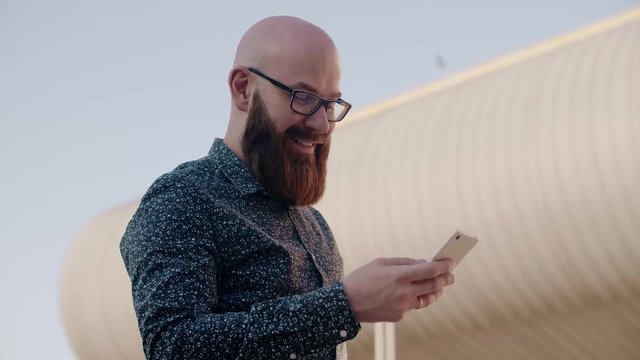 Hipster businessman using a smart phone outdoors