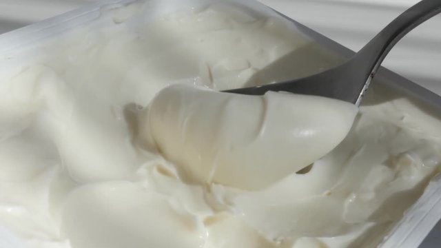 Close-up taking with creme cheese metallic spoon 4K footage
