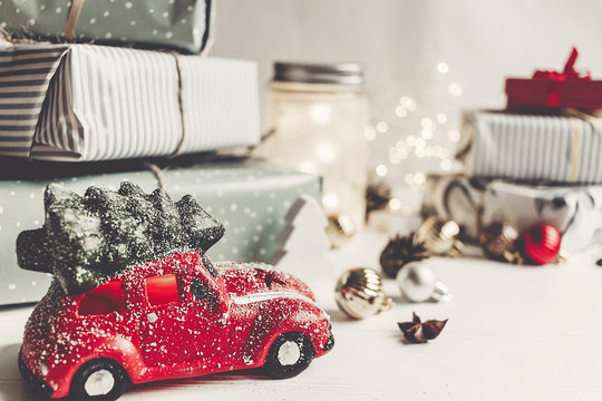 modern christmas ornaments and car toy with tree, presents cones anise on white wooden background. merry christmas concept. seasonal greetings. happy holidays, xmas card, hygge