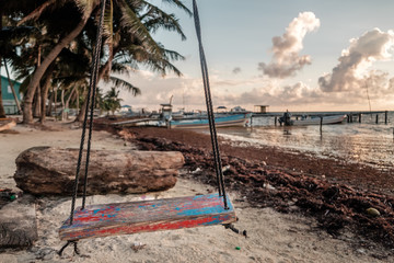 An old weathered swing on the shore of the Caribbean sea