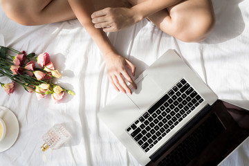 Woman Typing on Her Laptop at Her Bed