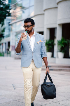 A young and handsome Indian Asian man walks down a street in Asia