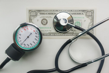 stethoscope and sphygmomanometer on a hundred dollars