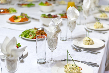 served holiday table, plates with dishes, salads, glasses, napkins, cutlery, tableware