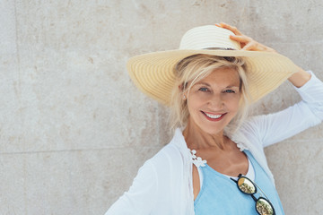 lächelnde ältere Frau mit einem Strohhut