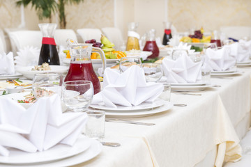served holiday table, dishes on plates, dishes, napkins, food, drinks, tablecloth