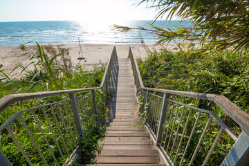 Escaliers en bois menant de la falaise sur le sable par une journée ensoleillée, escaliers en bois