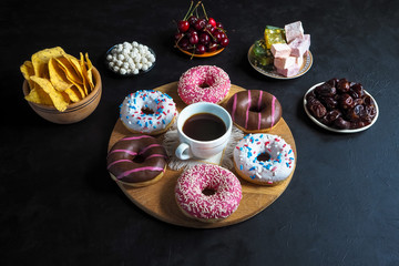 Obraz na płótnie Canvas Donut sweets and Turkish sweets on a black table with copy space