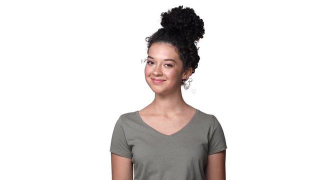 Portrait of joyful pretty woman 20s with dark curly hair nodding in approval meaning yes or agree, isolated over white background. Concept of emotions