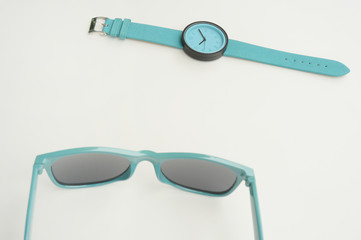 Set of multicolored wristwatches with fashionable sunglasses for background