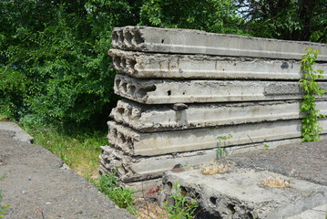 Reinforced concrete slabs for covering the floors of the house, the skeleton of the old collapsed species against the background of a green tree