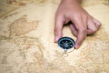 Hand catch compass on the old map