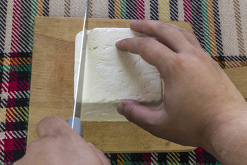 Cutting traditional bulgarian white cheese