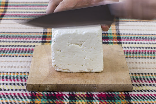 Cutting traditional bulgarian white cheese