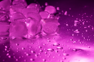 A pile of ice cubes in purple on a reflecting table