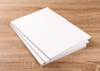 Fototapeta premium White blank magazines,book,brochures on wood table background.