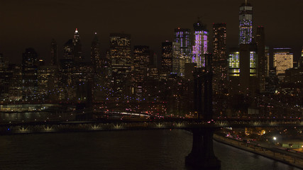 Fototapeta na wymiar AERIAL: The two bridges lit up at night connecting Brooklyn & downtown Manhattan