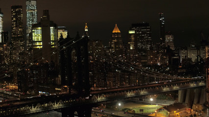 AERIAL, CLOSE UP: Cars crossing famous lit up Manhattan bridge at night in NYC