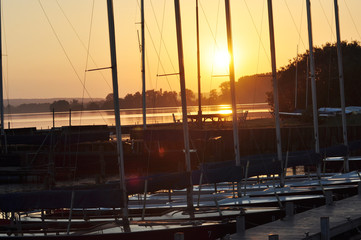 Ein kleiner Bootshafen am See bei Sonnenuntergang, Schiffe liegen vor Anker 