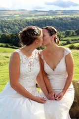 Same sex brides kissing on their wedding day in a rural marriage in the Yorkshire countryside 