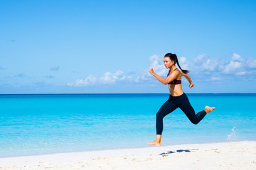 Beautiful sporty young woman is running on the beach on Bahamas iseland. Sport and sportswear concept. Outdoor shot.