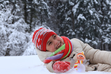 The frame depicts a winter forest, trees and pine trees. A child is playing with snow. Walk in the...