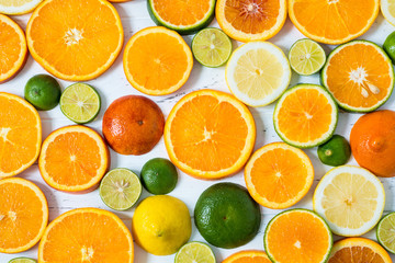 Citrus pattern on white wooden background. Assorted citrus fruits. Slices of orange, tangerine, lemon, lime. Top view.