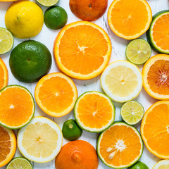 Citrus pattern on white wooden background. Assorted citrus fruits. Slices of orange, tangerine, lemon, lime. Top view. Square.