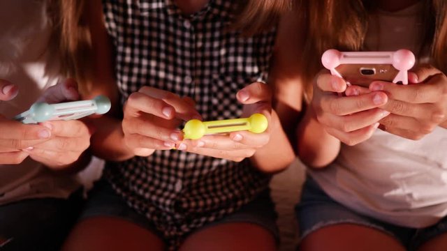 Type use smart phones chatting in social media three girls teenager sisters at home on bed in evening