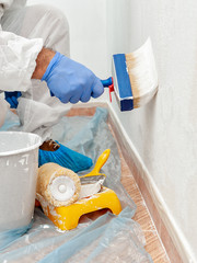 House painter at work painting a wall with a brush © francescomou