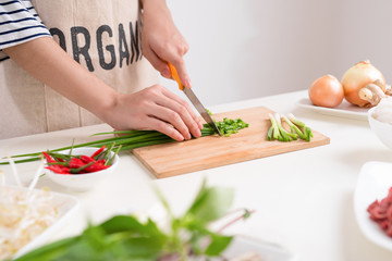 Female chef prepare traditional Vietnamese soup Pho bo with herbs, meat, rice noodles
