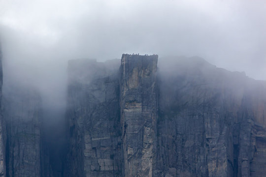 View of Preikestolen steep cliff in fog from the Lysefjorden, Rogaland, Norway