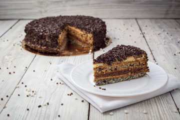 Dark chocolate vegan cake with candies and nuts on wooden background